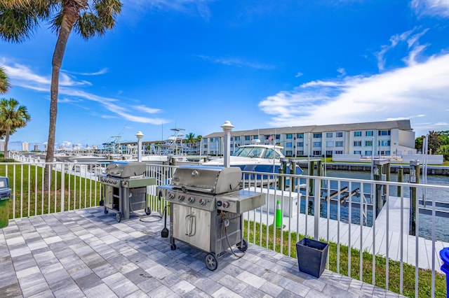 view of patio featuring a boat dock, a water view, a grill, and boat lift