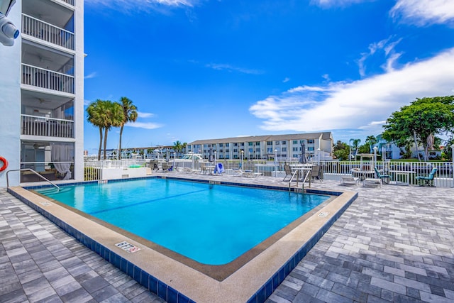 community pool featuring a ceiling fan, a patio area, and fence