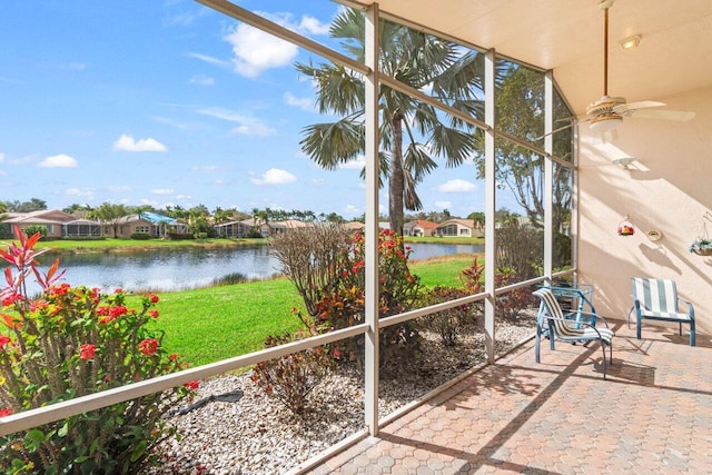 unfurnished sunroom with a water view and ceiling fan