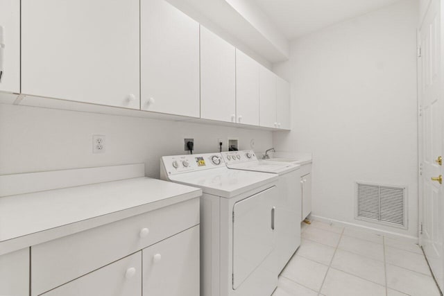 laundry room with cabinets, separate washer and dryer, and light tile patterned floors