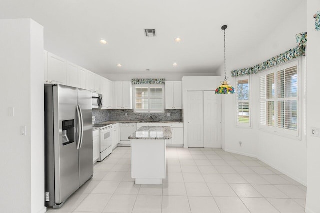 kitchen with pendant lighting, white cabinetry, a center island, and appliances with stainless steel finishes