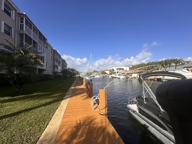 dock area with a water view and a yard