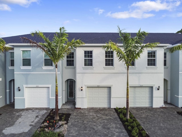 view of front of house featuring a garage, driveway, and stucco siding