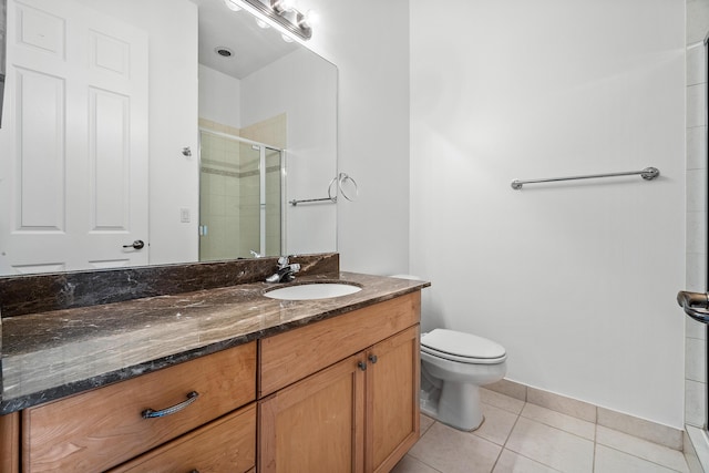 bathroom with tile patterned floors, toilet, an enclosed shower, and vanity