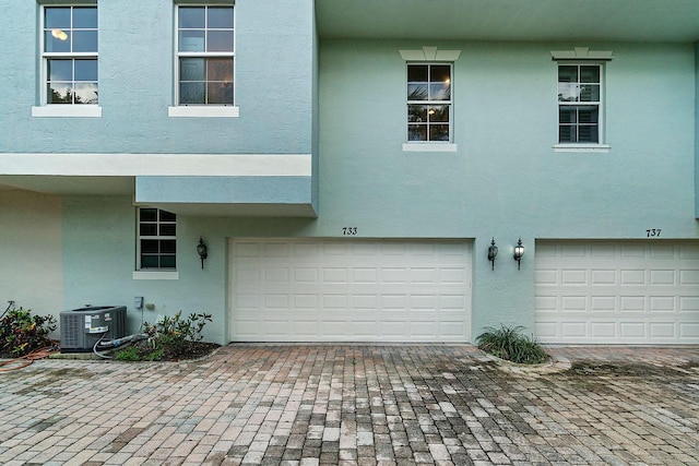 view of front facade with cooling unit and a garage