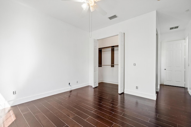 unfurnished bedroom featuring dark wood-type flooring, ceiling fan, and a closet