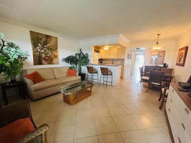 living area with a ceiling fan, crown molding, and light tile patterned floors