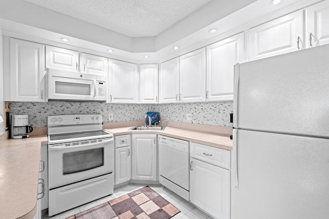 kitchen featuring light countertops, white appliances, a sink, and white cabinets