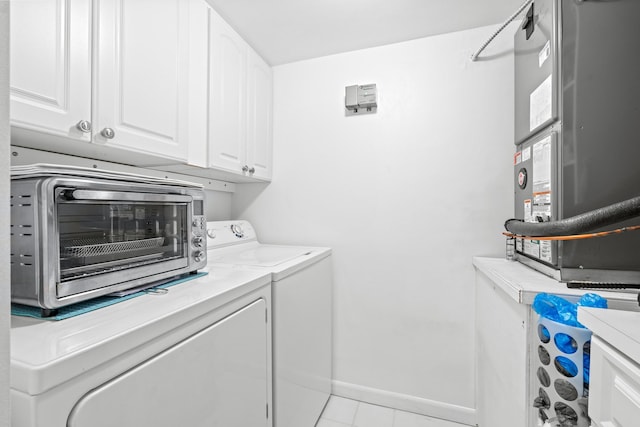 washroom with a toaster, separate washer and dryer, baseboards, cabinet space, and heating unit