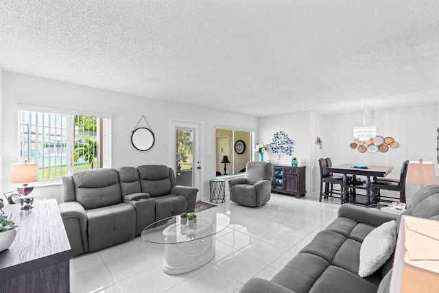 living area featuring a chandelier, a textured ceiling, and light tile patterned flooring