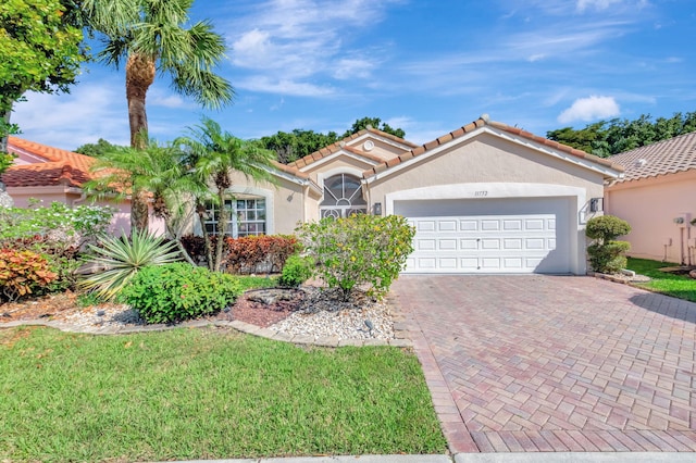 mediterranean / spanish-style home featuring a garage and a front yard