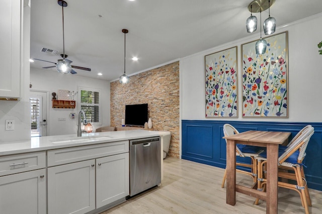 kitchen with sink, crown molding, light hardwood / wood-style flooring, hanging light fixtures, and stainless steel dishwasher