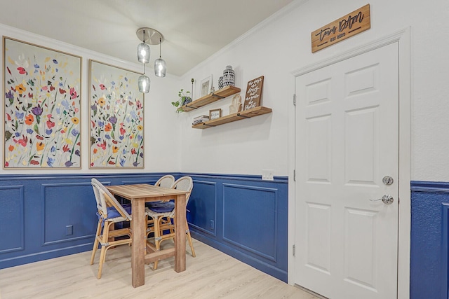 dining space featuring ornamental molding and light hardwood / wood-style flooring