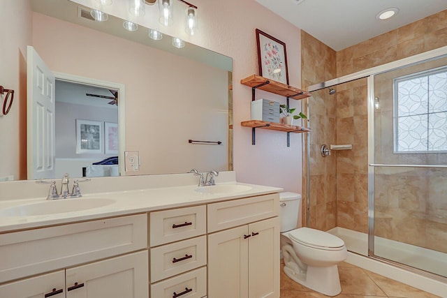 bathroom featuring vanity, a shower with shower door, tile patterned floors, and toilet