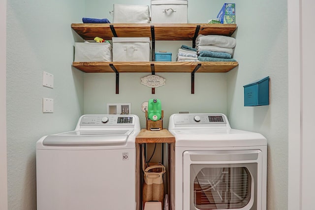 clothes washing area with washing machine and dryer