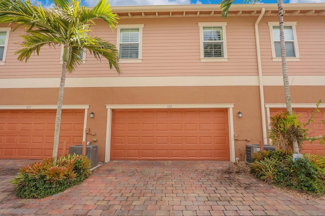 exterior space with a garage and central AC