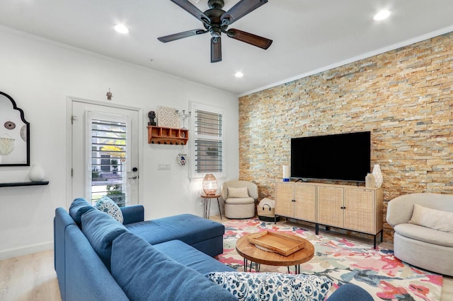 living room with hardwood / wood-style flooring, ceiling fan, and crown molding