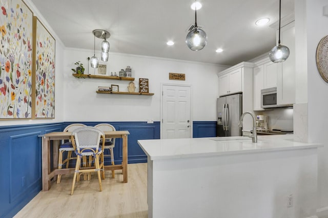 kitchen with white cabinetry, pendant lighting, stainless steel appliances, and kitchen peninsula