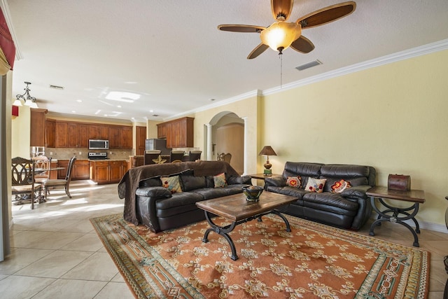 living room featuring light tile patterned floors, visible vents, arched walkways, and ornamental molding