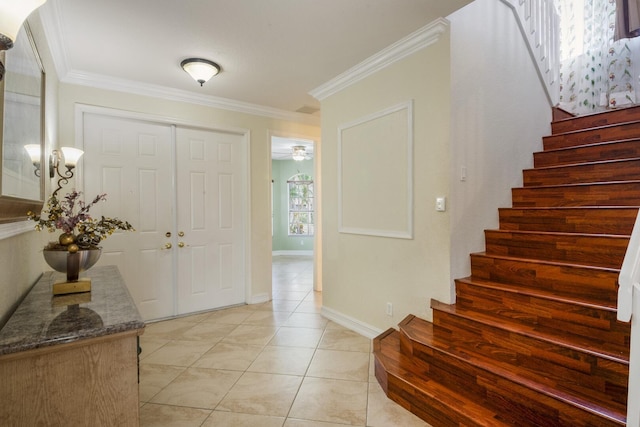 entrance foyer with light tile patterned floors, stairs, baseboards, and ornamental molding