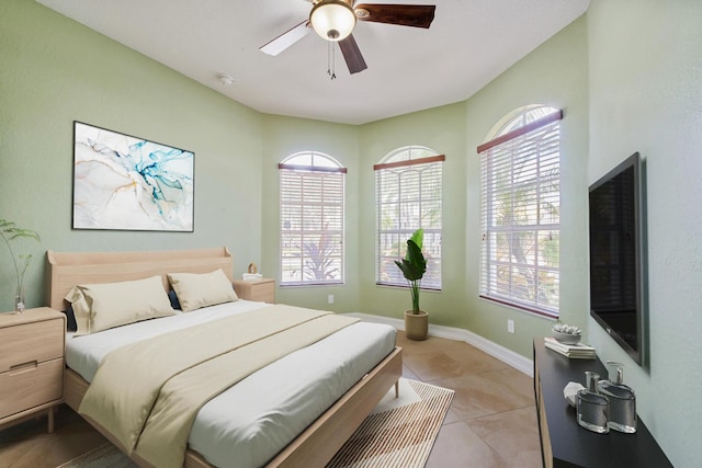 bedroom featuring light tile patterned floors, baseboards, and a ceiling fan