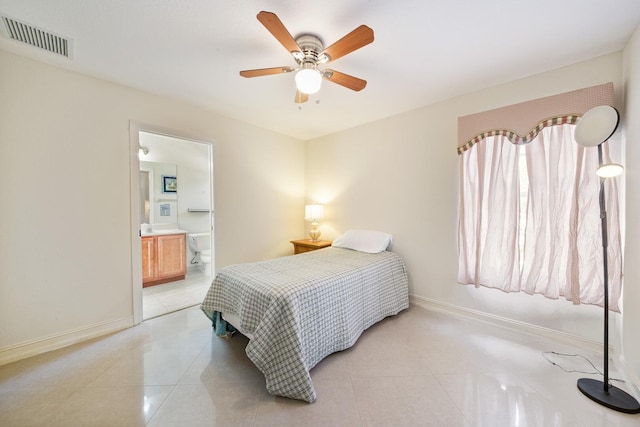 bedroom with light tile patterned flooring, visible vents, ensuite bath, and baseboards