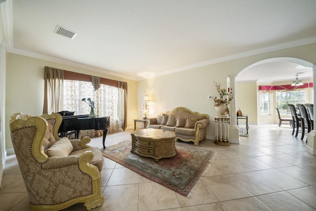 living area with arched walkways, visible vents, crown molding, and ornate columns