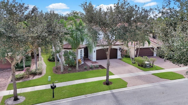 obstructed view of property featuring stucco siding, a front lawn, decorative driveway, a garage, and a tiled roof