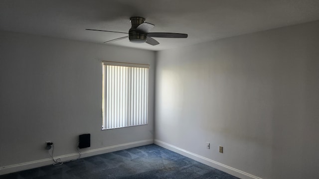 unfurnished room featuring dark carpet and ceiling fan