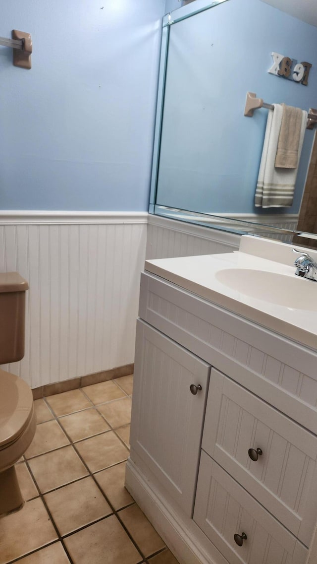 bathroom featuring tile patterned flooring, vanity, and toilet