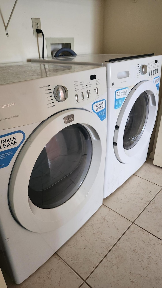 laundry room featuring washer and clothes dryer and tile patterned flooring