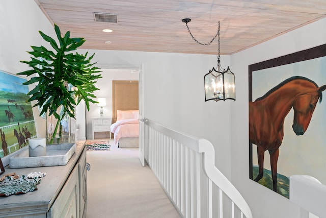 hallway with a chandelier and light carpet