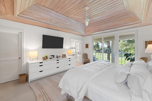 bedroom featuring a tray ceiling, access to exterior, light carpet, and wooden ceiling