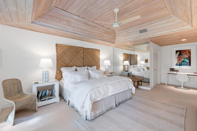 carpeted bedroom featuring wood ceiling and a tray ceiling