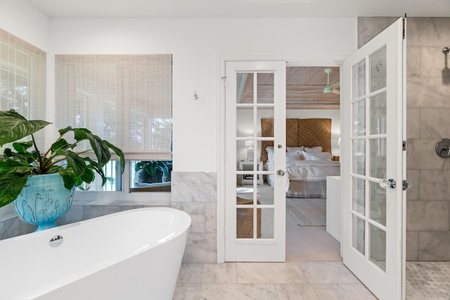 bathroom with a washtub and french doors