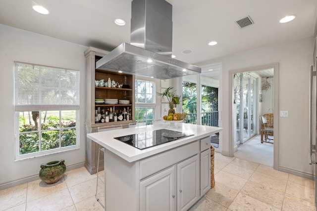 kitchen featuring a breakfast bar area, white cabinetry, a center island, black electric stovetop, and island exhaust hood