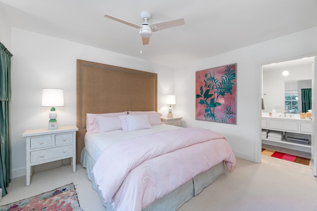 carpeted bedroom with ensuite bathroom, sink, and ceiling fan