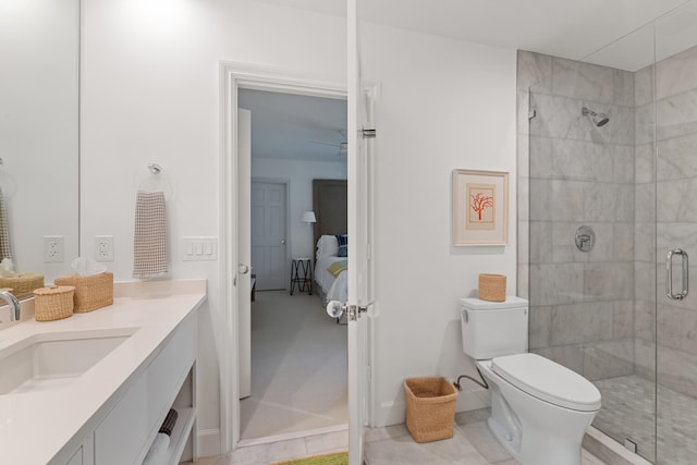 bathroom featuring a shower with door, vanity, ceiling fan, and toilet