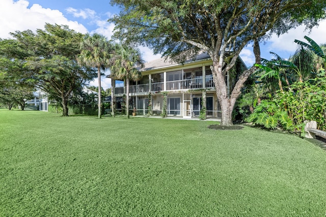 back of property with a yard and a sunroom