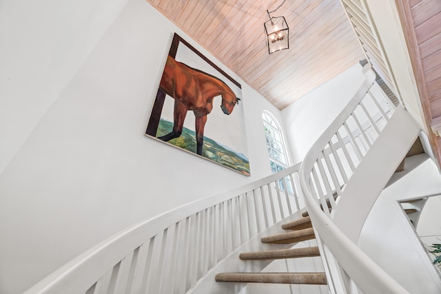 staircase featuring high vaulted ceiling and wood ceiling