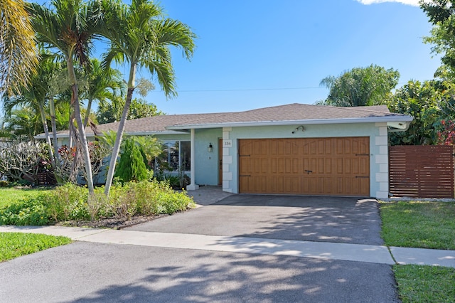 single story home featuring driveway, a shingled roof, an attached garage, and stucco siding