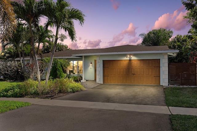 view of front facade with a garage, driveway, roof with shingles, and stucco siding