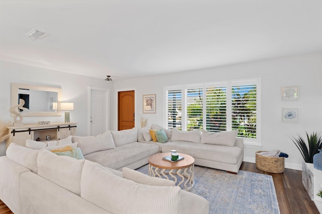 living room featuring baseboards, visible vents, and dark wood-type flooring