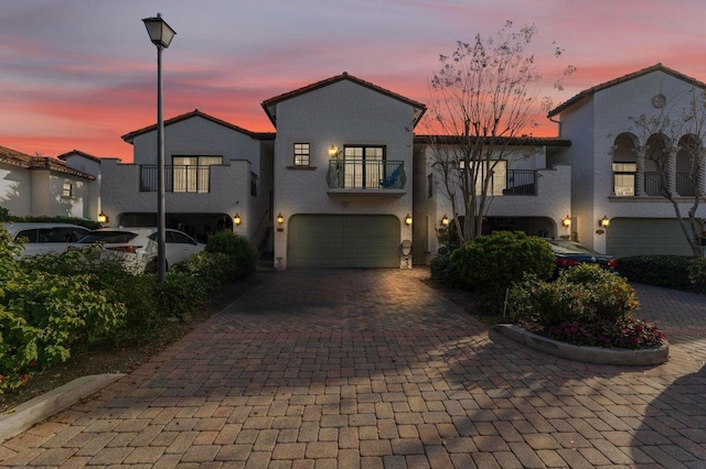 view of front of home with a garage and a balcony