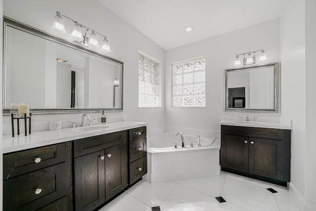 full bath with a garden tub, two vanities, a sink, and tile patterned flooring