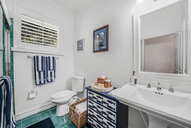 bathroom featuring baseboards, toilet, ornamental molding, tile patterned flooring, and a sink