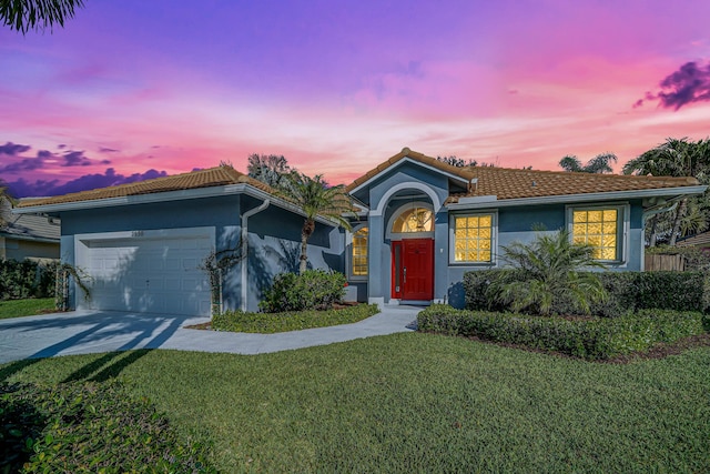 ranch-style home with concrete driveway, a lawn, an attached garage, and stucco siding