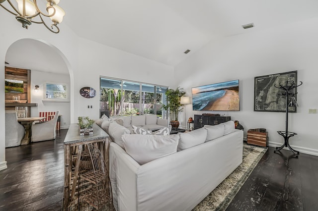 living area featuring arched walkways, visible vents, baseboards, wood-type flooring, and an inviting chandelier