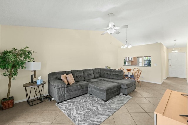 living room featuring lofted ceiling, light tile patterned floors, baseboards, and ceiling fan with notable chandelier