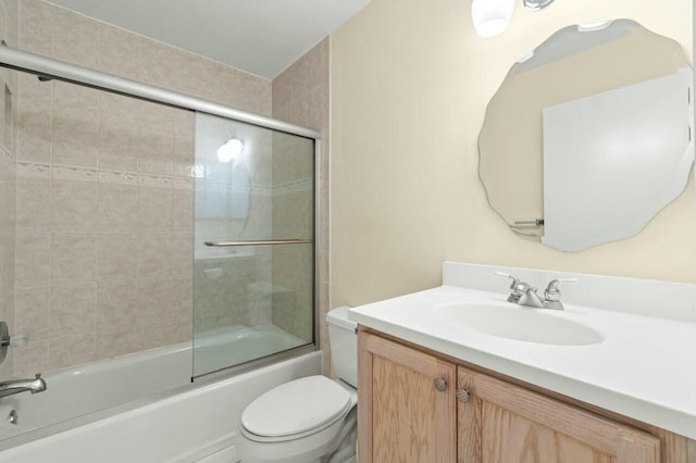 bathroom with bath / shower combo with glass door, vanity, and toilet